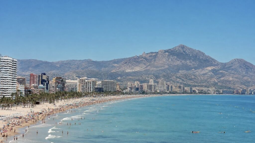 Panoramic view of Playa de San Juan and Muchavista beach shoreline with coastal skyline and Puig Campana mountain peak in the background
